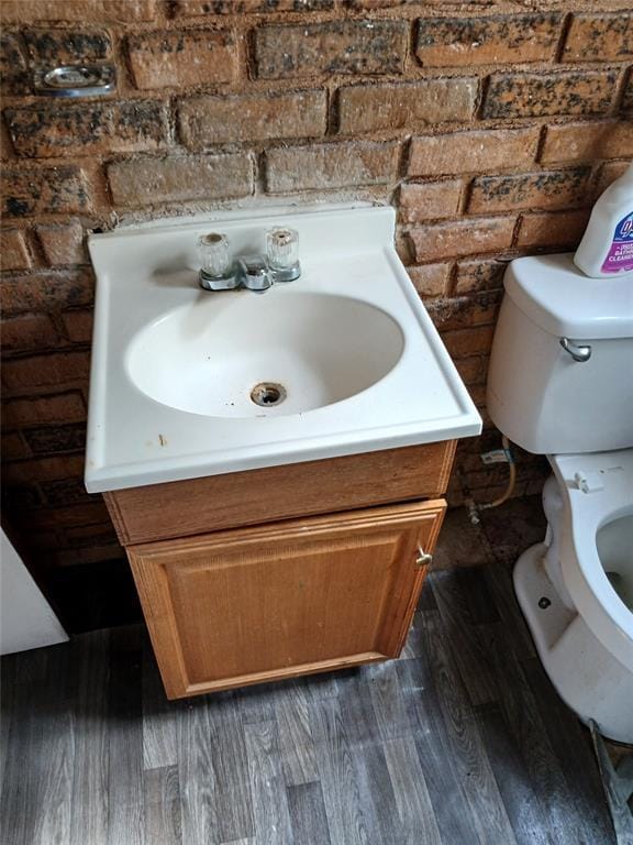 bathroom featuring toilet, vanity, and wood finished floors