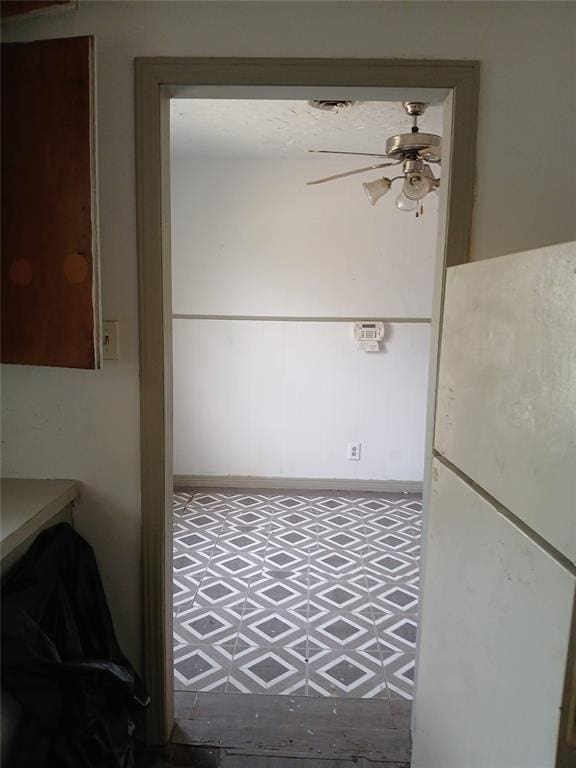 interior space with tile patterned floors and a ceiling fan