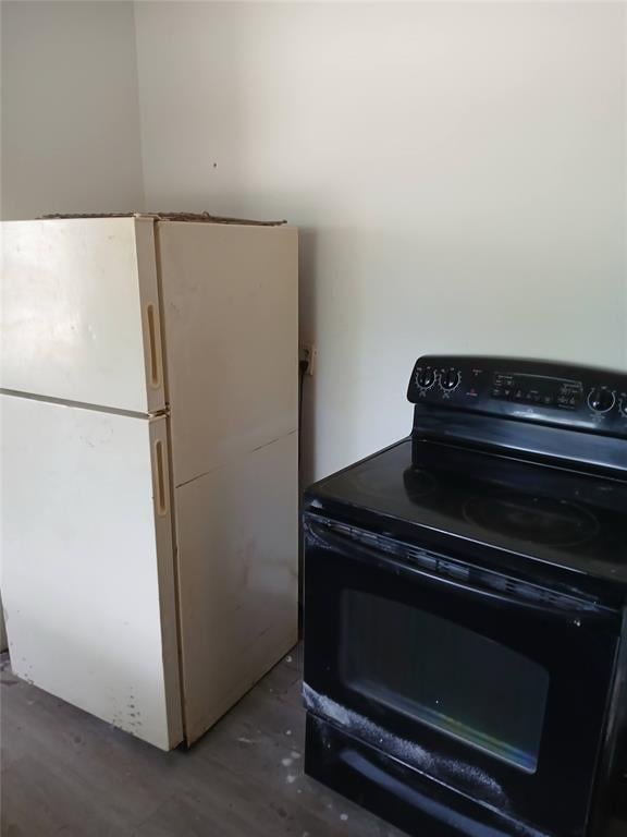 kitchen featuring black electric range oven and freestanding refrigerator