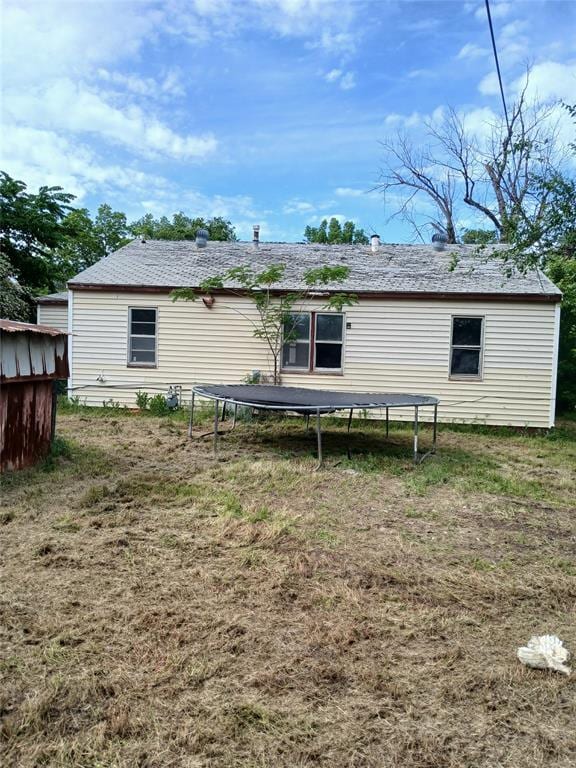 back of property featuring a trampoline