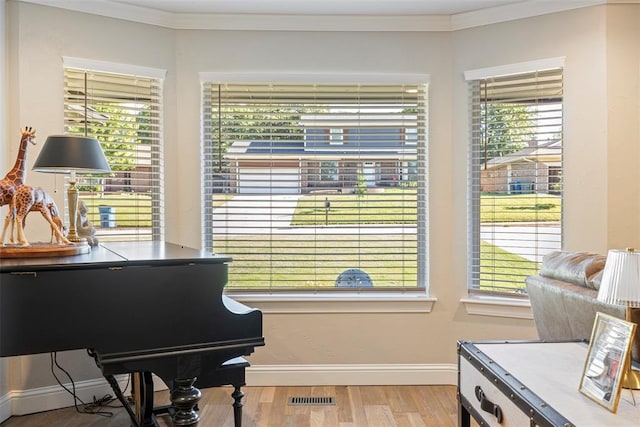 sitting room featuring crown molding, wood finished floors, and baseboards