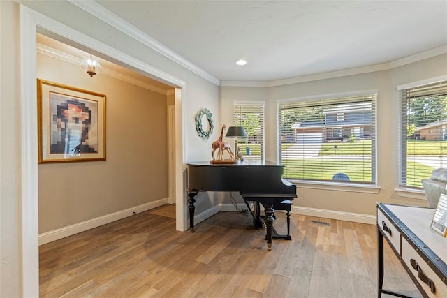 living area featuring light wood finished floors, baseboards, and ornamental molding
