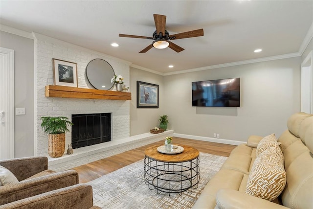 living room featuring wood finished floors, ceiling fan, a brick fireplace, recessed lighting, and baseboards