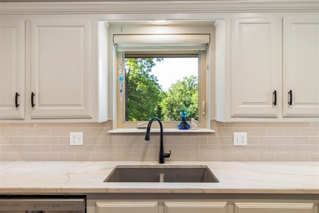 kitchen with a sink, dishwashing machine, decorative backsplash, white cabinetry, and light stone counters