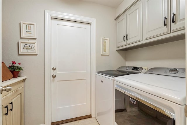 laundry area featuring separate washer and dryer, cabinet space, and a desk