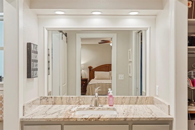 ensuite bathroom featuring vanity, ceiling fan, and recessed lighting