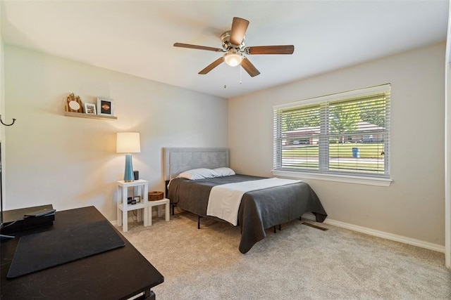 bedroom with light carpet, a ceiling fan, and baseboards