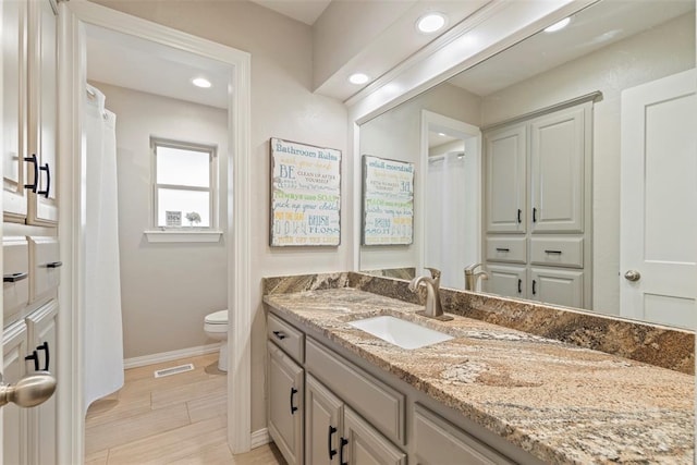 bathroom with toilet, baseboards, recessed lighting, and vanity