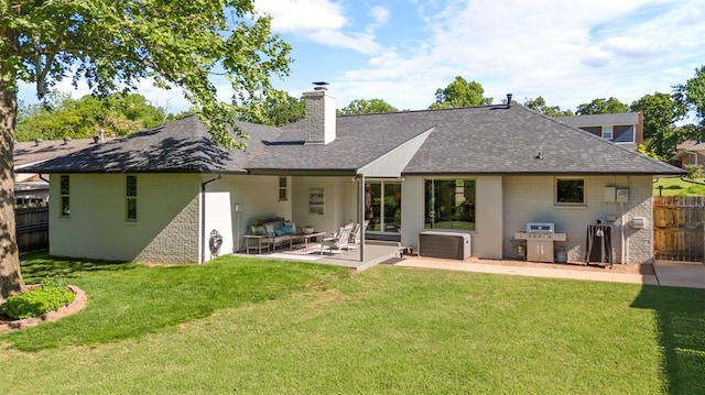 back of property featuring brick siding, a chimney, a patio, and a shingled roof