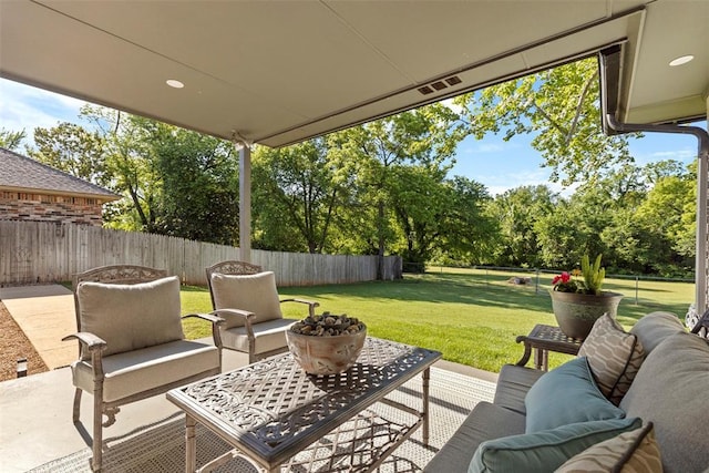 view of patio / terrace with an outdoor living space and view of wooded area