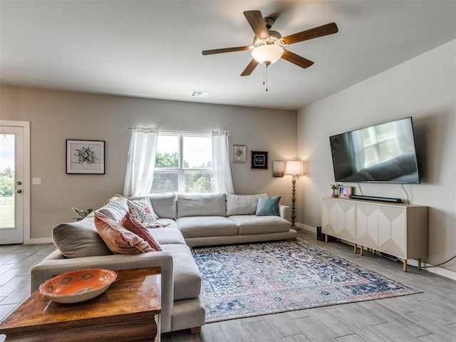 living area featuring ceiling fan, wood finished floors, and baseboards