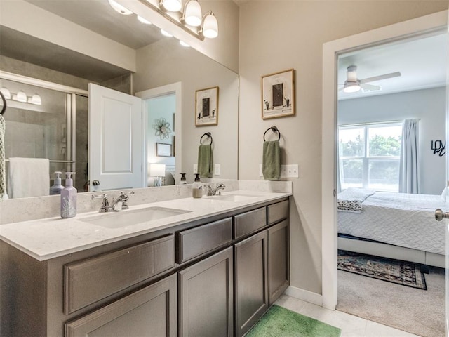 ensuite bathroom featuring tile patterned flooring, double vanity, baseboards, and ceiling fan