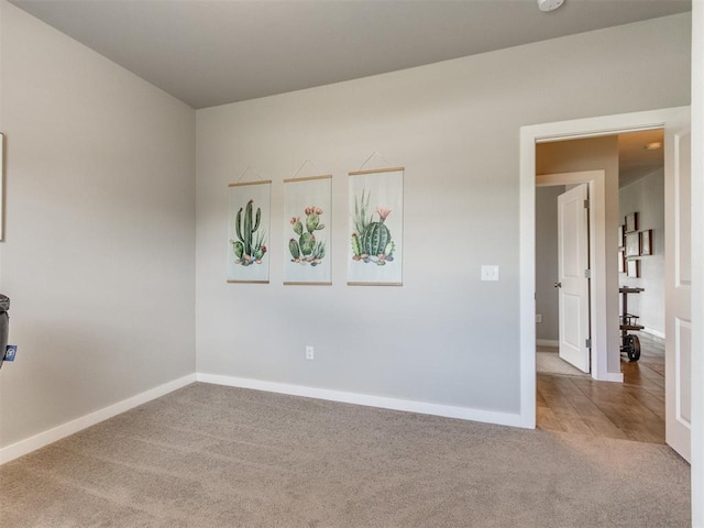 unfurnished room with carpet, baseboards, and a smoke detector