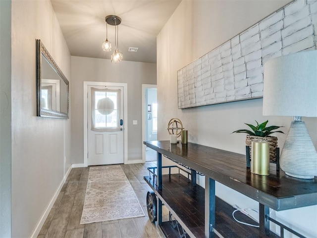 foyer entrance with wood finished floors and baseboards
