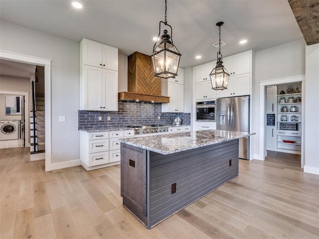 3241 E 171st St, Bixby, OK 74008 - kitchen featuring stainless steel appliances, washer / dryer, custom range hood, light wood-type flooring, and recessed lighting