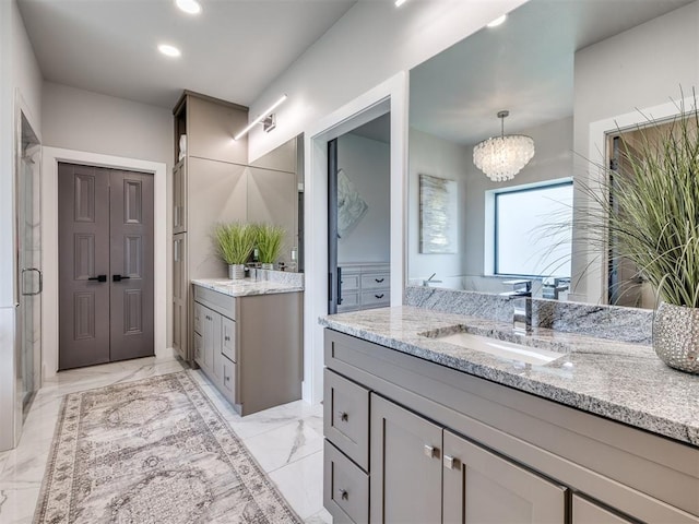 3241 E 171st St, Bixby, OK 74008 - full bathroom featuring two vanities, marble finish flooring, a chandelier, a stall shower, and recessed lighting