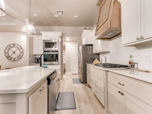 kitchen featuring stainless steel appliances, custom exhaust hood, light countertops, light wood-style floors, and tasteful backsplash