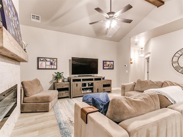 living area with light wood-style flooring, a glass covered fireplace, a ceiling fan, and baseboards