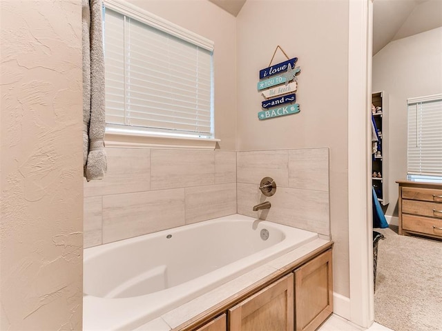 full bath featuring a garden tub and baseboards