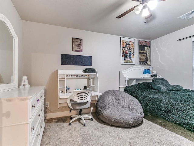 bedroom with light carpet, ceiling fan, and a desk