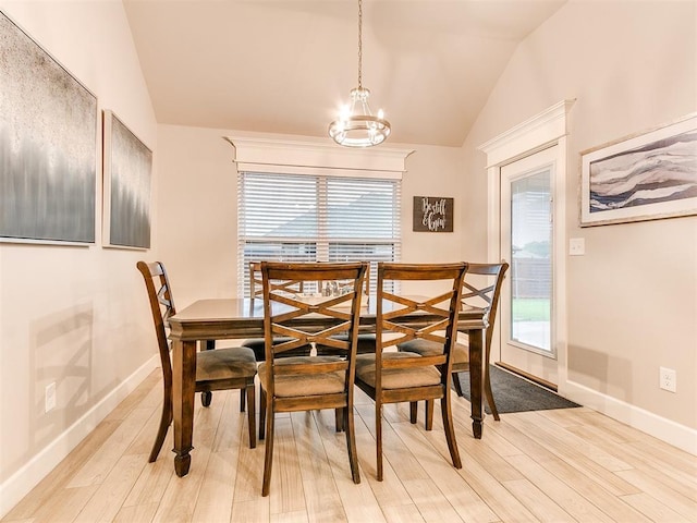 dining area featuring vaulted ceiling, light wood finished floors, a chandelier, and baseboards