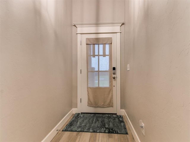 doorway to outside featuring wood finished floors and baseboards