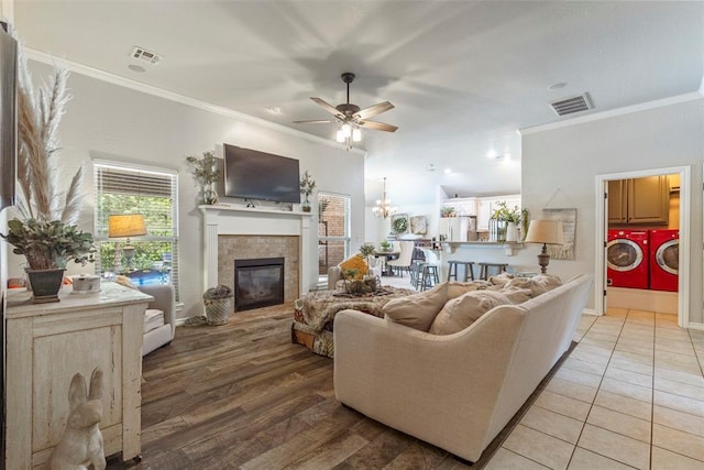 13141 Austrian Pine Dr, Choctaw, OK 73020 - living area featuring separate washer and dryer, a fireplace, crown molding, ceiling fan, and a chandelier