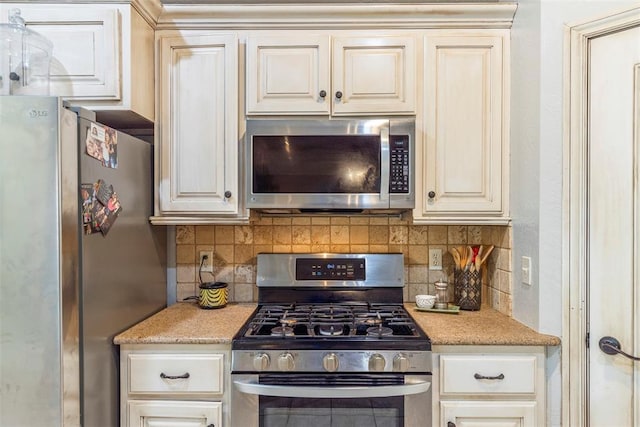 13141 Austrian Pine Dr, Choctaw, OK 73020 - kitchen featuring appliances with stainless steel finishes, backsplash, light stone counters, and cream cabinetry
