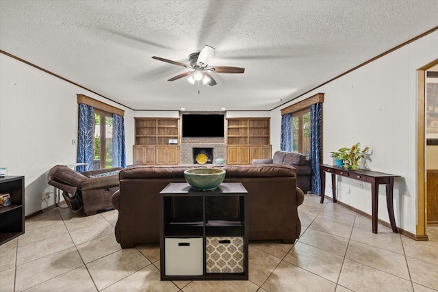 3926 Briarcrest Dr, Norman, OK 73072 - living room with ceiling fan, plenty of natural light, a fireplace, a textured ceiling, and light tile patterned floors