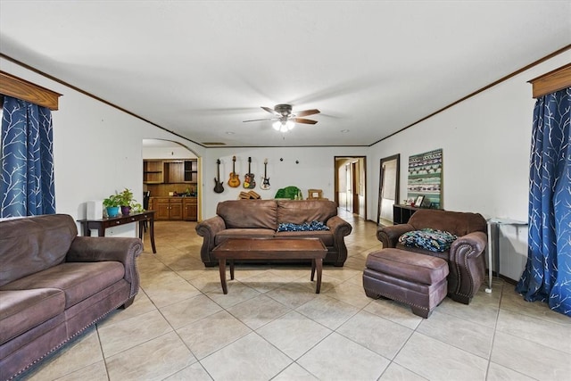 3926 Briarcrest Dr, Norman, OK 73072 - living room featuring light tile patterned floors, ornamental molding, a ceiling fan, and arched walkways