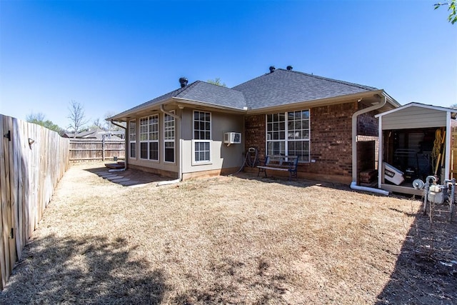 717 Hunters Run, Midwest City, OK 73130 - back of property featuring a fenced backyard, roof with shingles, an AC wall unit, and brick siding