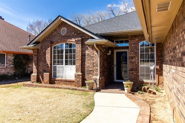 717 Hunters Run, Midwest City, OK 73130 - doorway to property with brick siding and roof with shingles