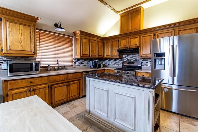 717 Hunters Run, Midwest City, OK 73130 - kitchen with stainless steel appliances, a sink, under cabinet range hood, brown cabinetry, and lofted ceiling