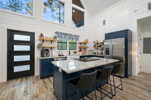 48 Cedar Hills Trl, Broken Bow, OK 74728 - kitchen with open shelves, high vaulted ceiling, stainless steel fridge with ice dispenser, wooden walls, and blue cabinets