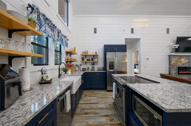 48 Cedar Hills Trl, Broken Bow, OK 74728 - kitchen featuring open shelves, blue cabinets, a sink, stainless steel appliances, and wood finished floors