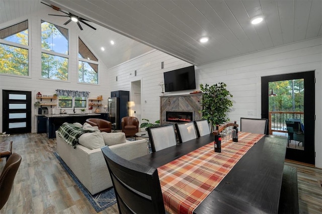 48 Cedar Hills Trl, Broken Bow, OK 74728 - dining area featuring light wood-style floors, a premium fireplace, plenty of natural light, a ceiling fan, and high vaulted ceiling