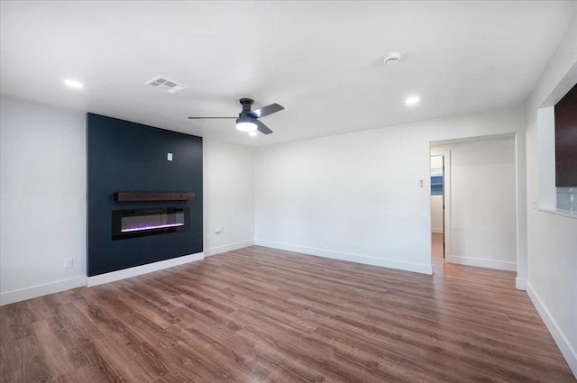 825 W Colorado Ave, Chickasha, OK 73018 - unfurnished living room with wood finished floors, a fireplace, a ceiling fan, baseboards, and recessed lighting