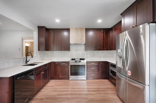 825 W Colorado Ave, Chickasha, OK 73018 - kitchen featuring appliances with stainless steel finishes, a sink, tasteful backsplash, light wood-style flooring, and dark brown cabinetry
