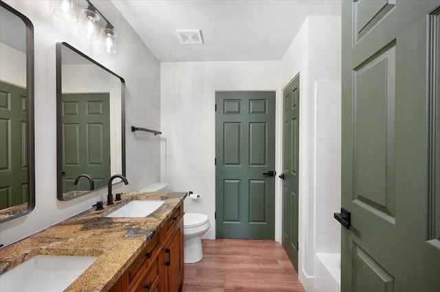 825 W Colorado Ave, Chickasha, OK 73018 - full bathroom featuring toilet, wood finished floors, double vanity, a bath, and a shower
