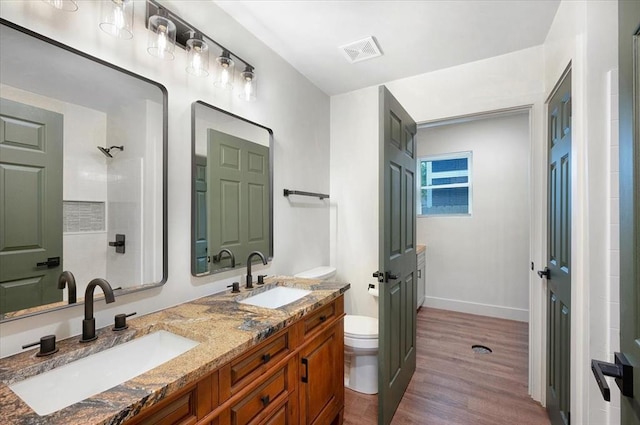 825 W Colorado Ave, Chickasha, OK 73018 - full bath featuring wood finished floors, toilet, a shower, double vanity, and baseboards
