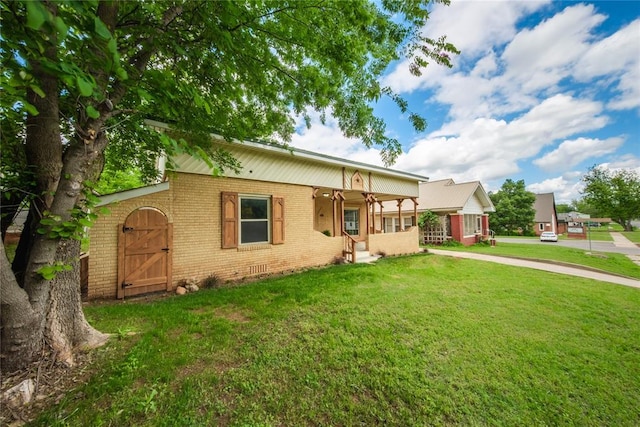view of front of property featuring brick siding, a front lawn, and a porch