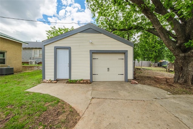 detached garage featuring concrete driveway and central AC