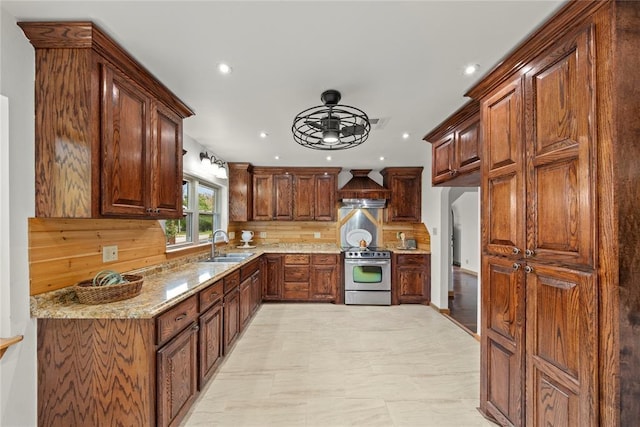 kitchen featuring stainless steel range with electric cooktop, a sink, light stone counters, recessed lighting, and decorative backsplash