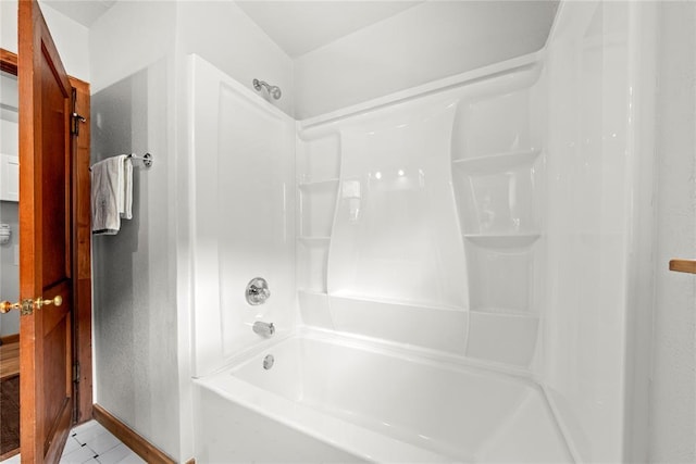 bathroom with shower / tub combination and baseboards