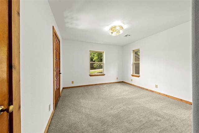 carpeted spare room featuring baseboards