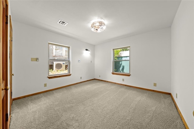 spare room featuring light colored carpet and baseboards