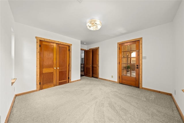 unfurnished bedroom featuring baseboards and light colored carpet