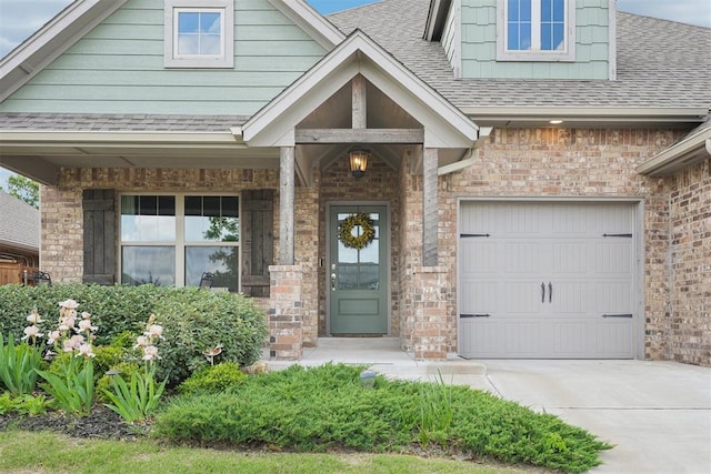 8400 Poplar Dr, Edmond, OK 73034 - doorway to property featuring a shingled roof, concrete driveway, brick siding, and a porch