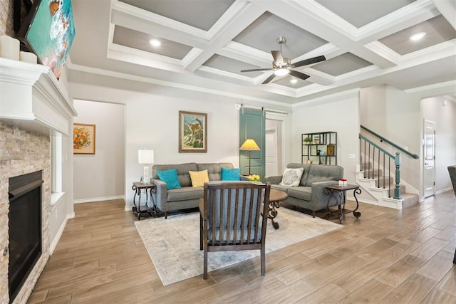 8400 Poplar Dr, Edmond, OK 73034 - living area featuring a stone fireplace, stairs, light wood finished floors, crown molding, and beam ceiling