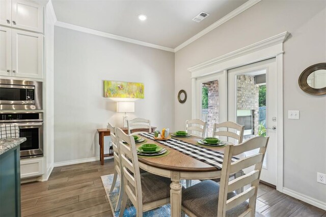 8400 Poplar Dr, Edmond, OK 73034 - dining area with wood finished floors, crown molding, and recessed lighting